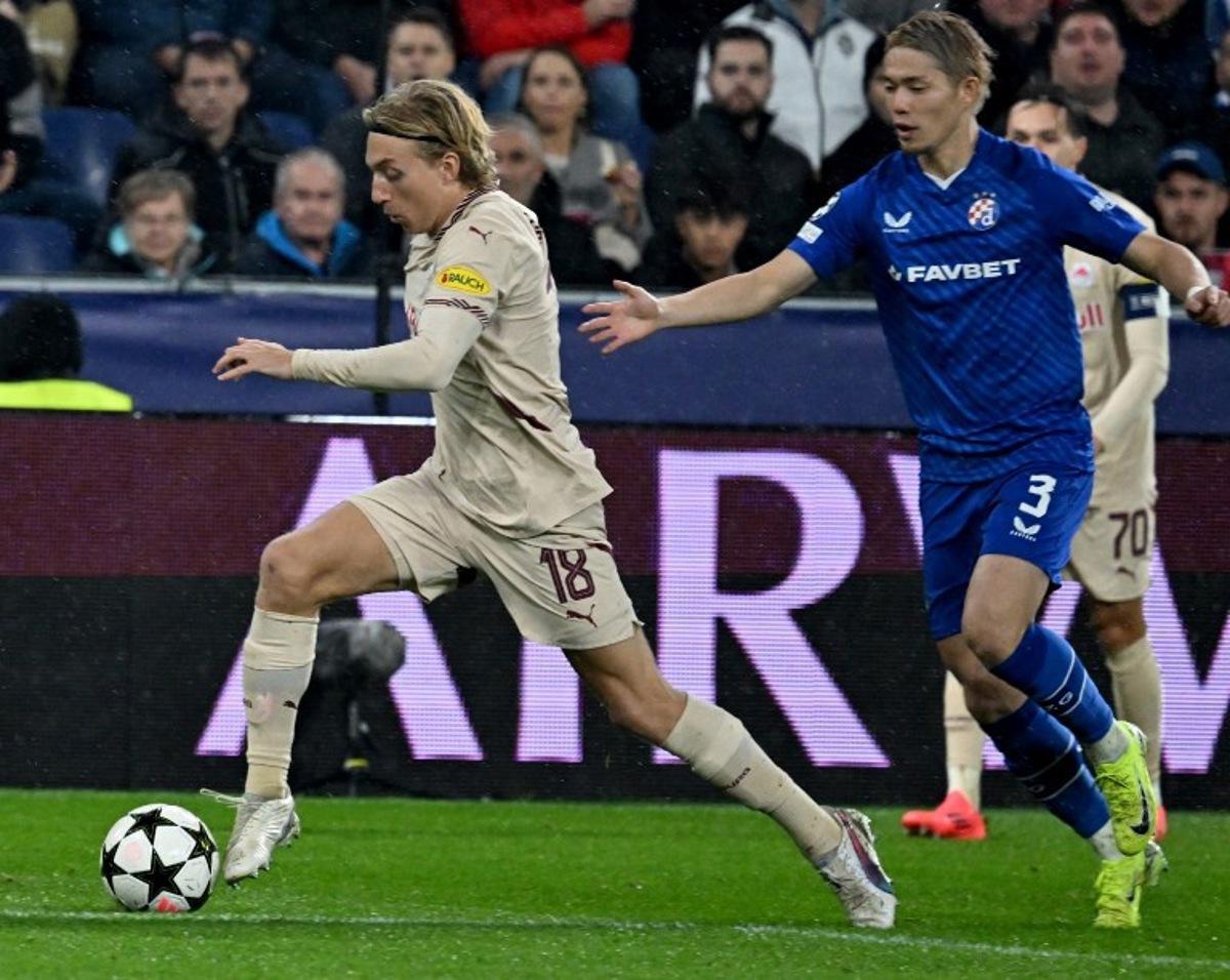 Salzburg's Danish midfielder #18 Mads Bidstrup (L) and Dinamo Zagreb's Japanese defender #03 Takuya Ogiwara vie for the ball during the UEFA Champions League football match between Salzburg and GNK Dinamo Zagreb in Salzburg, Austria on October 23, 2024.   BARBARA GINDL / APA / AFP