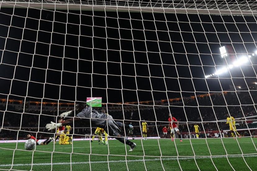 Egypt's forward #10 Mohamed Salah scores past Zimbabwe's goalkeeper #22 Washington Arubi during the Africa Cup of Nations (CAN) group B football match between Egypt and Zimbabwe at Adrar Stadium in Agadir on December 22, 2025.   FRANCK FIFE / AFP