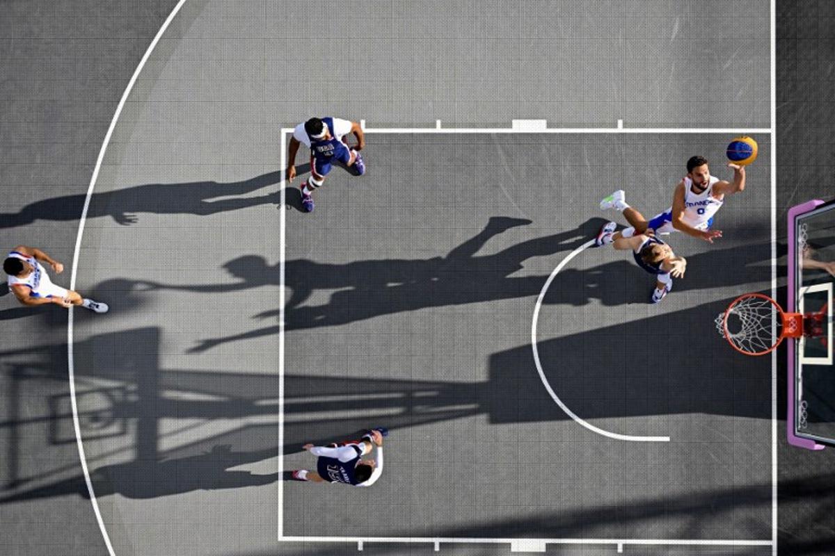 An overview shows France's #00 Lucas Dussoulier going to the basket in the men's pool round 3x3 basketball game between France and the USA during the Paris 2024 Olympic Games at La Concorde in Paris on August 2, 2024.  Odd ANDERSEN / AFP