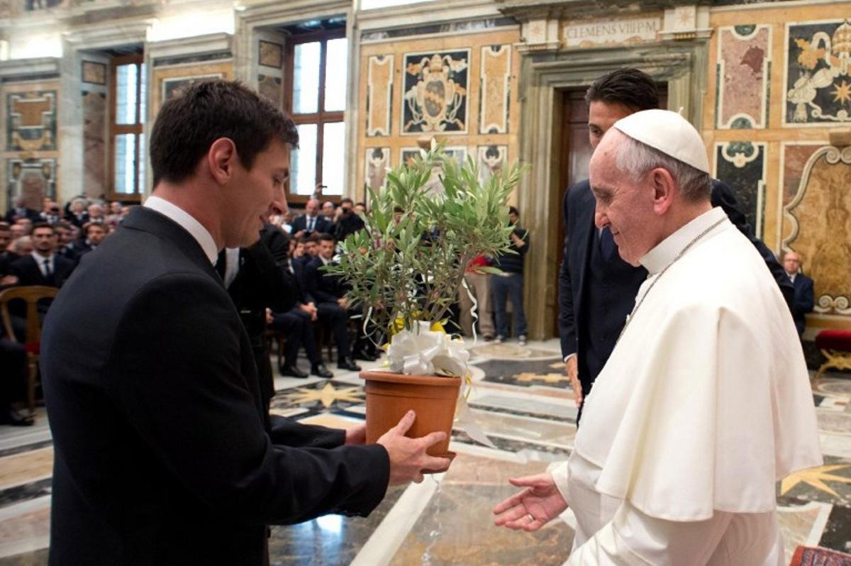 Pope Francis (C) receives an olive tree from Argentine forward Lionel Messi (L) at the end of a private audience together at the Vatican on August 13, 2013. Argentina's national football team will play a friendly match against Italy's national football team on August 14, 2013.   AFP PHOTO/ OSSERVATORE ROMANO RESTRICTED TO EDITORIAL USE - MANDATORY CREDIT "AFP PHOTO / OSSERVATORE ROMANO " - NO MARKETING / NO ADVERTISING CAMPAIGNS - DISTRIBUTED AS A SERVICE TO CLIENTS  HO / OSSERVATORE ROMANO / AFP