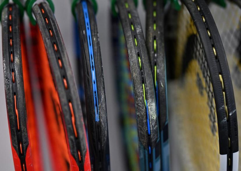Players' freshly restrung tennis racquets hang awaiting collection in the racquet stringing department, before the start of play on the seventh day of the 2024 Wimbledon Championships at The All England Lawn Tennis and Croquet Club in Wimbledon, southwest London, on July 7, 2024.  Glyn KIRK / AFP
