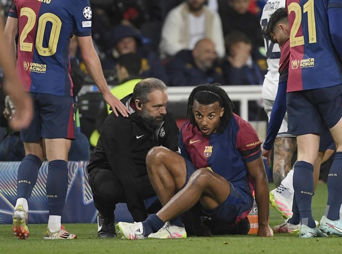 Medical staff's member tends to Barcelona's French defender #23 Jules Kounde during the UEFA Champions League semi final first leg football match between FC Barcelona and Inter Milan at the Estadi Olimpic Lluis Companys in Barcelona on April 30, 2025.  Josep LAGO / AFP
