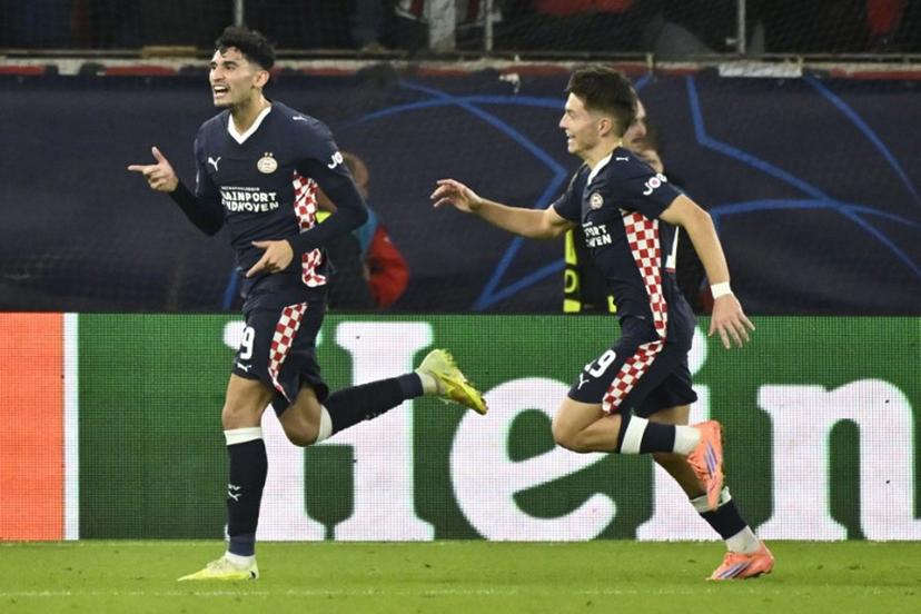 PSV Eindhoven's US forward #09 Ricardo Pepi (L) celebrates after scoring PSV's first goal during the UEFA Champions League first round day 4 football match between Olympiakos (GRE) and PSV Eindhoven (NED) at the Karaiskakis stadium in Piraeus on November 4, 2025.  Aris MESSINIS / AFP