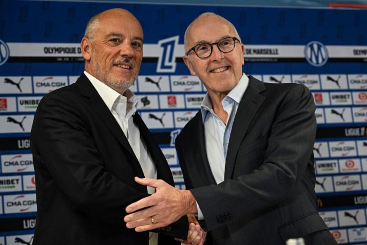 French fooball club Olympique de Marseille (OM) US owner Frank McCourt (R) shakes hand with the club's new president Stephane Richard (L) at the start of a press conference at the Velodrome Stadium in Marseille, southeastern France, on April 10, 2026.  Gabriel BOUYS / AFP
