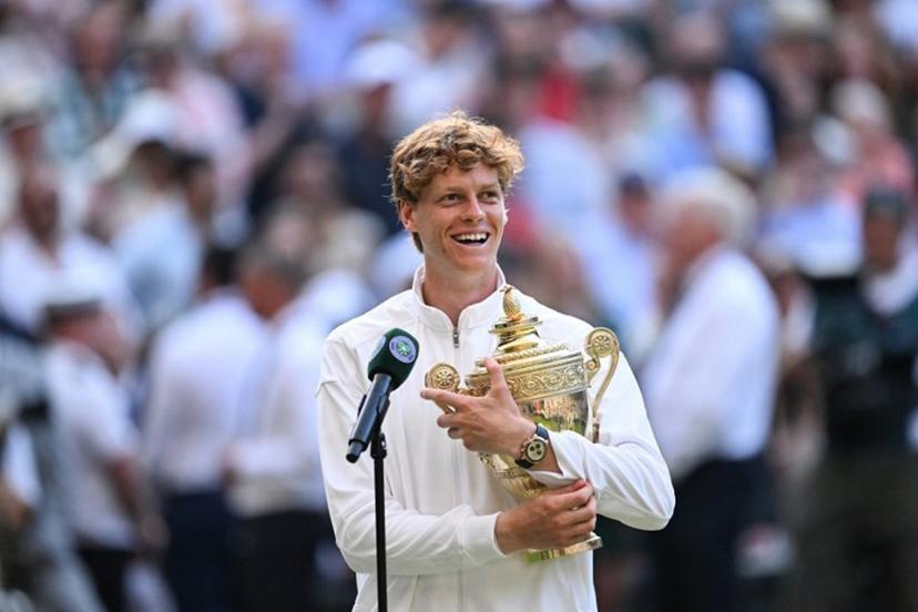 Italy's Jannik Sinner speaks to the audience with his trophy following his victory against Spain's Carlos Alcaraz at the end of their men's singles final tennis match on the fourteenth day of the 2025 Wimbledon Championships at The All England Lawn Tennis and Croquet Club in Wimbledon, southwest London, on July 13, 2025.  Kirill KUDRYAVTSEV / AFP