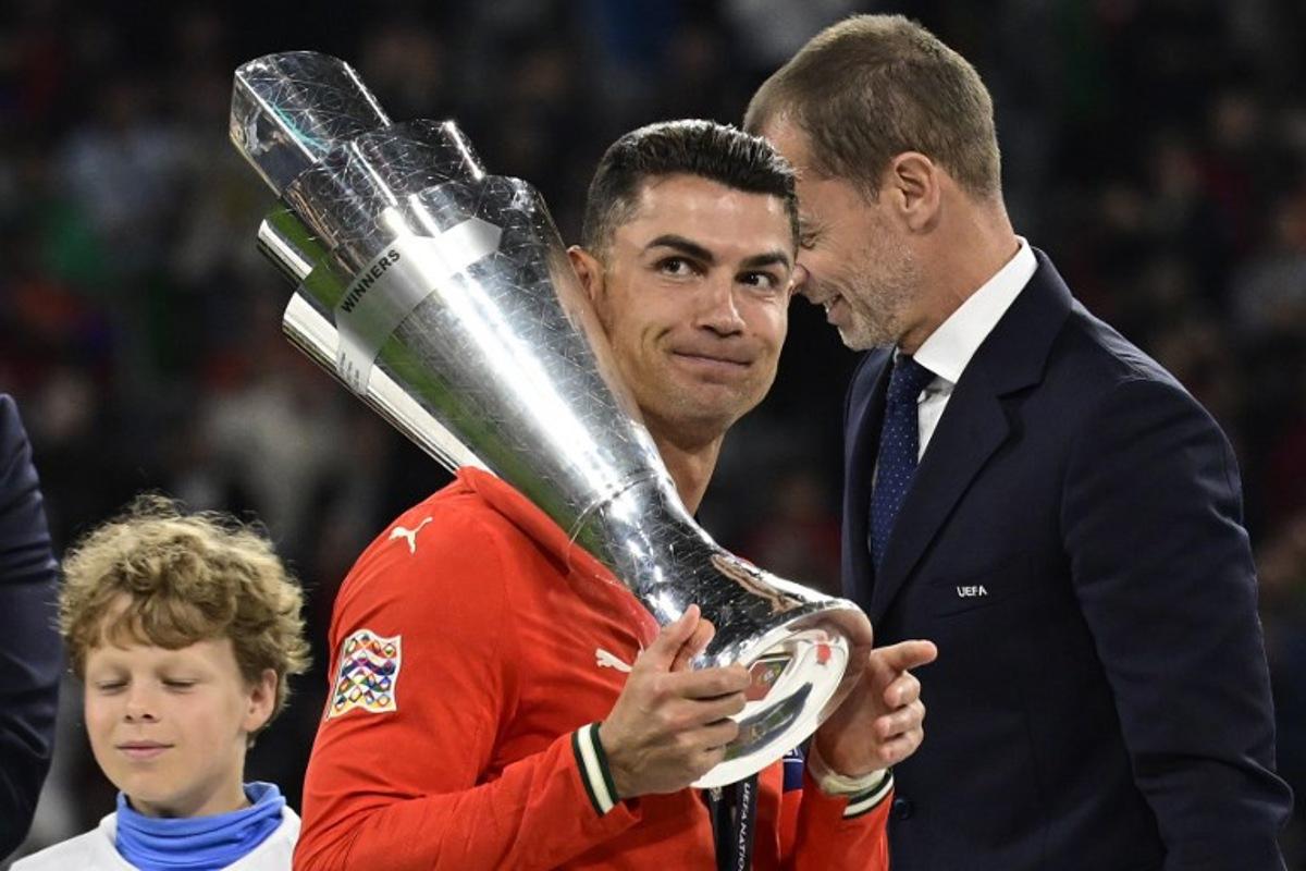 Portugal's forward #07 Cristiano Ronaldo carries the trophy after winning the UEFA Nations League final football match between Portugal and Spain in Munich, southern Germany on June 8, 2025.  John MACDOUGALL / AFP