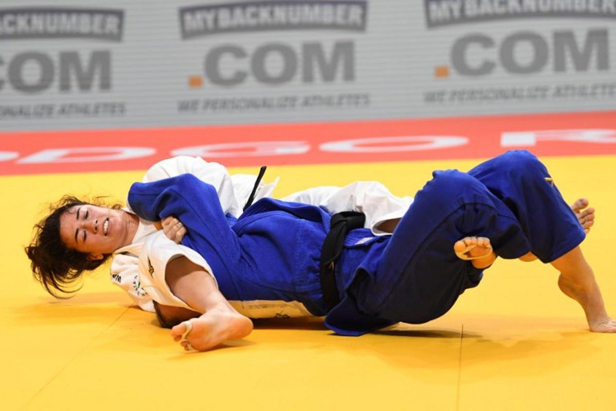 Germany's Friederike Stolze (Blue) and Belgium's Gabriella Willems (White) compete in the women's -70 kg bout during the Judo's European Championships in Podgorica, on April 27, 2025. The tournament is taking place from April 23 to 27, 2025.   SAVO PRELEVIC / AFP