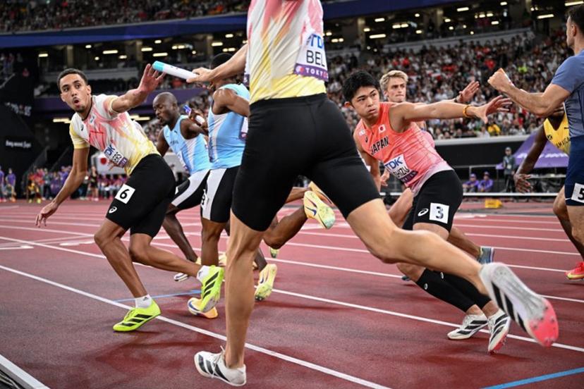 Athletes including Belgium's athlete Daniel Segers (L) receive the baton as they compete in the men's 4x400m relay heat 2 during the World Athletics Championships in Tokyo on September 20, 2025.  Kirill KUDRYAVTSEV / AFP