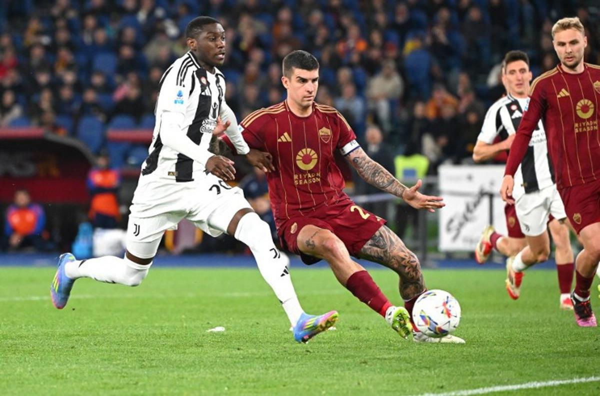 Juventus' French forward #20 Kolo Muani (L) fights for the ball with Roma's Italian defender #23 Gianluca Mancini during the Italian Serie A football match AS Roma vs Juventus at Olympic stadium in Rome on April 6, 2025.  Alberto PIZZOLI / AFP