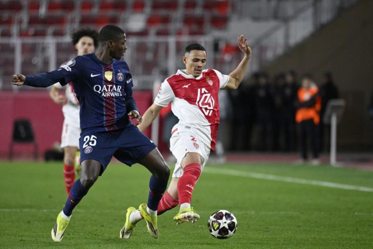 Monaco's Brazilian defender #02 Vanderson (R) and Paris Saint-Germain's Portuguese defender #25 Nuno Mendes fight for the ball during the UEFA Champions League knockout round play-off first leg football match between AS Monaco and Paris Saint-Germain at the Stade Louis II in the Principality of Monaco on February 17, 2026.  Frederic Dides / AFP