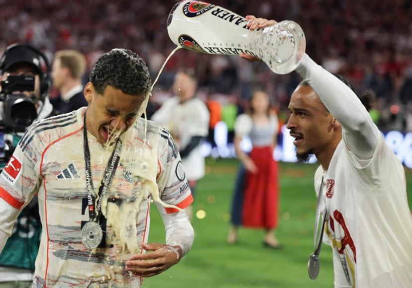 Bayern Munich's German midfielder #42 Jamal Musiala is doused with beer by Bayern Munich's German forward #10 Leroy Sane after the German first division Bundesliga football match between Bayern Munich and Borussia Moenchengladbach in Munich on May 10, 2025.  Alexandra BEIER / AFP