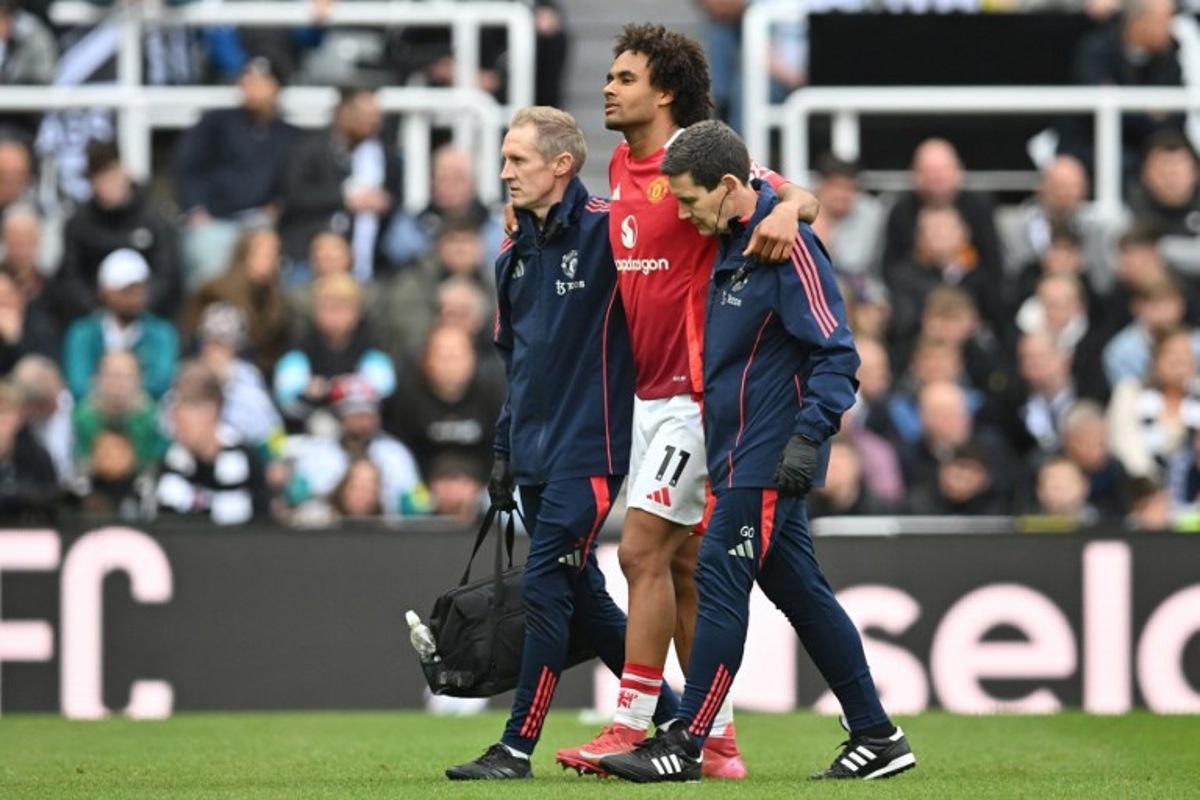 Manchester United's Dutch striker #11 Joshua Zirkzee is helped off the pitch after picking up an injury during the English Premier League football match between Newcastle United and Manchester United at St James' Park in Newcastle-upon-Tyne, north east England on April 13, 2025.  ANDY BUCHANAN / AFP