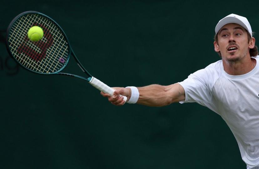 Australia's Alex De Minaur plays a forehand return to Denmark's August Holmgren during their men's singles third round tennis match on the sixth day of the 2025 Wimbledon Championships at The All England Lawn Tennis and Croquet Club in Wimbledon, southwest London, on July 5, 2025.  Adrian Dennis / AFP