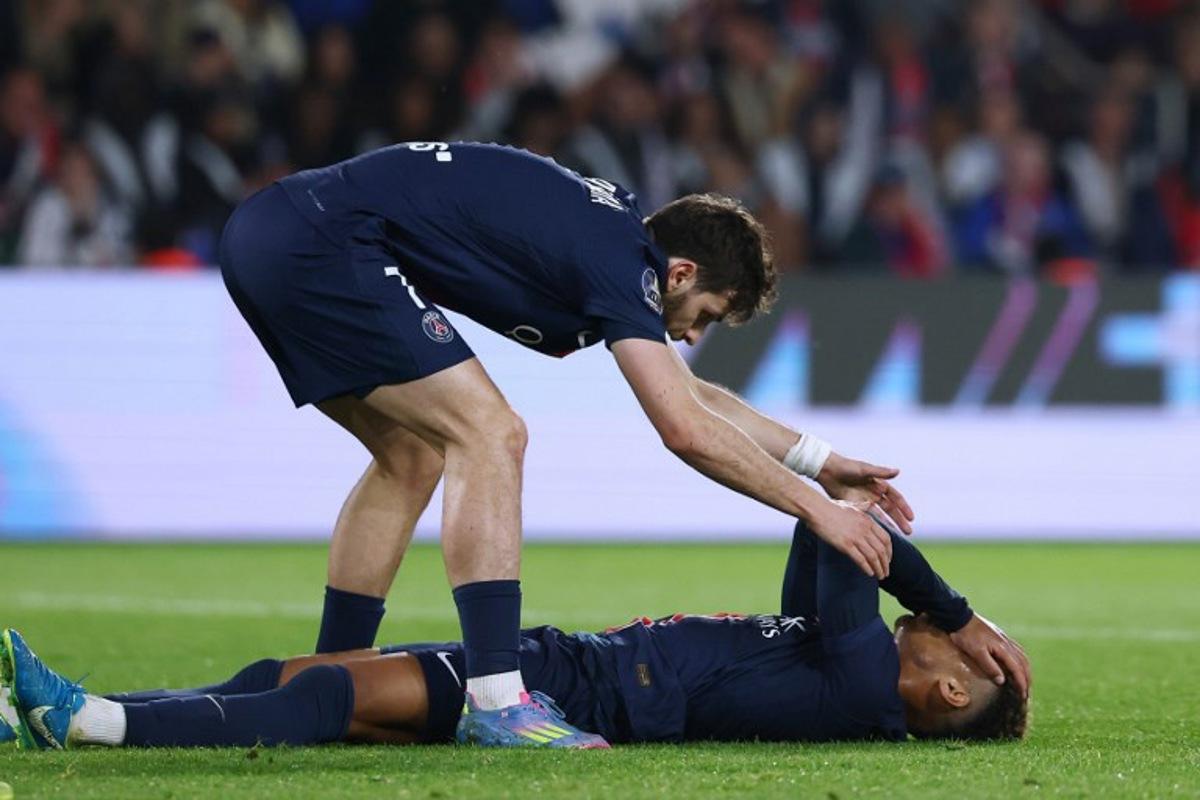 Paris Saint-Germain's French midfielder #14 Desire Doue (R) reacts with Paris Saint-Germain's Georgian forward #07 Khvicha Kvaratskhelia after missing a goal opportunity during the French L1 football match between Paris Saint-Germain (PSG) and OGC Nice at the Parc des Princes stadium in Paris, on April 25, 2025.  FRANCK FIFE / AFP