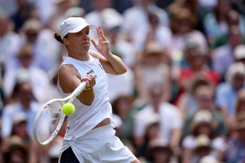 Poland's Iga Swiatek returns to Philippines' Alexandra Eala during their women's singles third round tennis match on the sixth day of the 2026 Wimbledon Championships at The All England Lawn Tennis and Croquet Club in Wimbledon, southwest London, on July 4, 2026.  Henry Nicholls / AFP