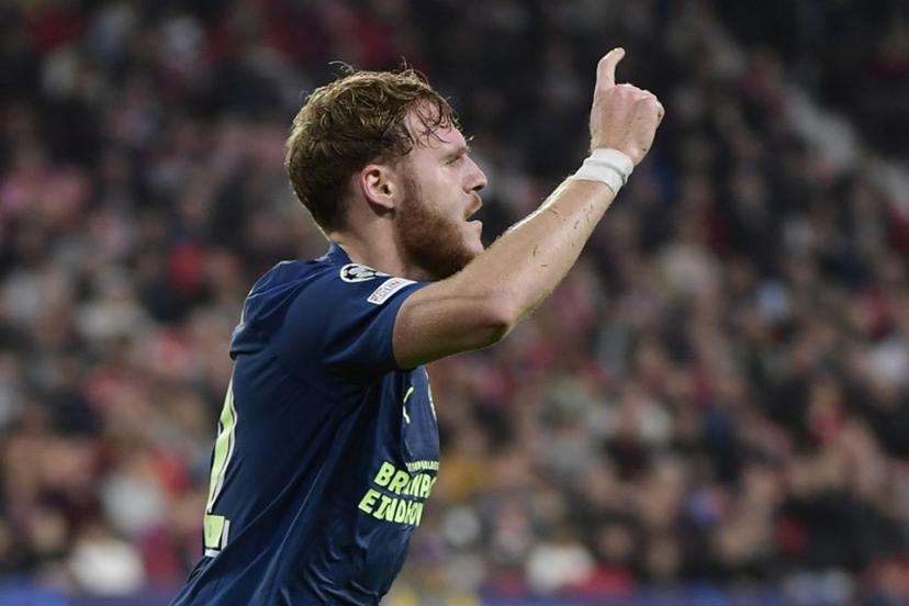 PSV's Belgian forward #32 Yorbe Vertessen celebrates Sevilla's Serbian midfielder #06 Nemanja Gudelj's owngoal during the UEFA Champions League first round group B football match between Sevilla FC and PSV Eindhoven at the Ramon Sanchez Pizjuan stadium in Seville on November 29, 2023.  CRISTINA QUICLER / AFP