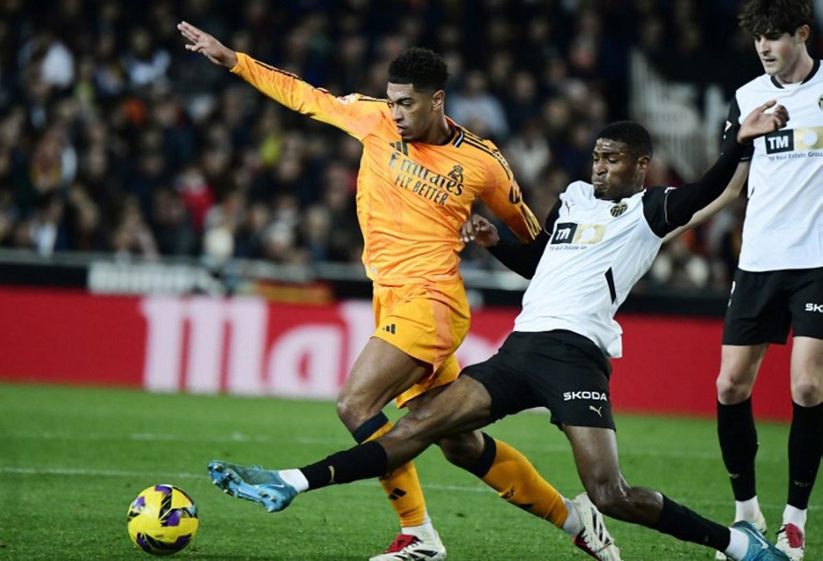 Real Madrid's English midfielder #05 Jude Bellingham (L) and Valencia's Spanish defender #03 Cristhian Mosquera fight for the ball during the Spanish league football match between Valencia CF and Real Madrid CF at the Mestalla stadium in Valencia on January 3, 2025.  JOSE JORDAN / AFP