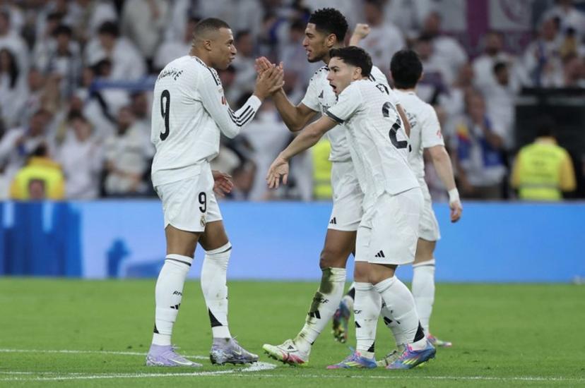 Real Madrid's English midfielder #05 Jude Bellingham (C) celebrates scoring their second goal with Real Madrid's French forward #09 Kylian Mbappe during the Spanish league football match between Real Madrid CF and Club Deportivo Leganes SAD at the Santiago Bernabeu stadium in Madrid on March 29, 2025.  Thomas COEX / AFP