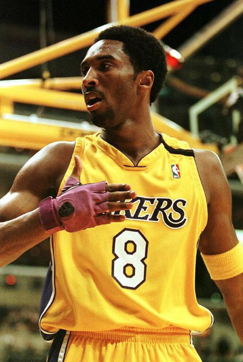 Kobe Bryant of the Los Angeles Lakers gestures to fans after scoring his first basket of the season against the Golden State Warriors 01 December 1999 in Los Angeles, Ca. It was Bryant's first game of the season after recovering from a broken bone in his right hand during the pre-season. AFP PHOTO/Vince BUCCI  VINCE BUCCI / AFP