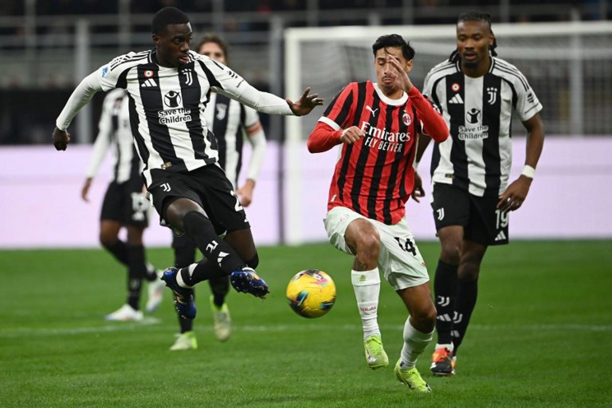 Juventus' US forward #22 Timothy Weah (L) fights for the ball with AC Milan's Dutch midfielder #14 Tijani Reijnders during the Italian Serie A football match between AC Milan and Juventus Turin at San Siro stadium in Milan, on November 23, 2024.  Isabella BONOTTO / AFP