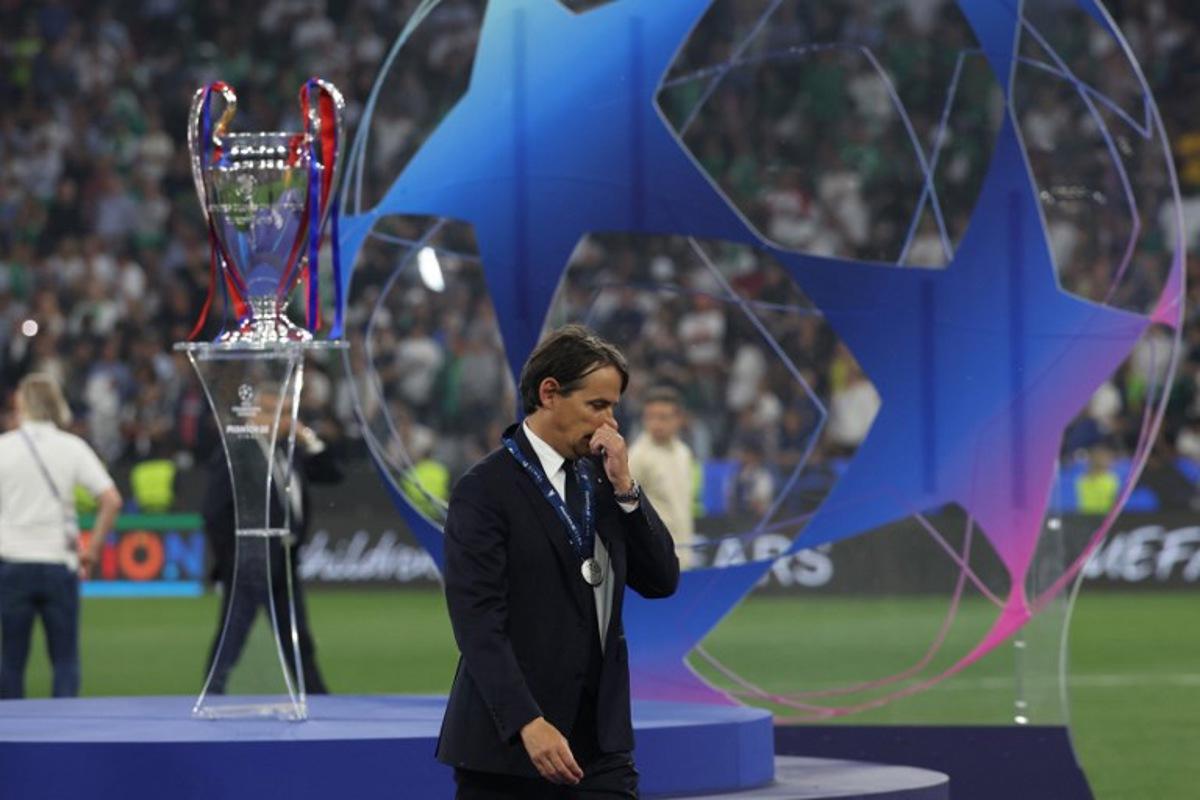 Inter Milan's Italian coach Simone Inzaghi reacts as he walks past the UEFA Champions League trophy at the end of the UEFA Champions League final football match between Paris Saint-Germain (PSG) and Inter Milan in Munich, southern Germany, on May 31, 2025.  FRANCK FIFE / AFP