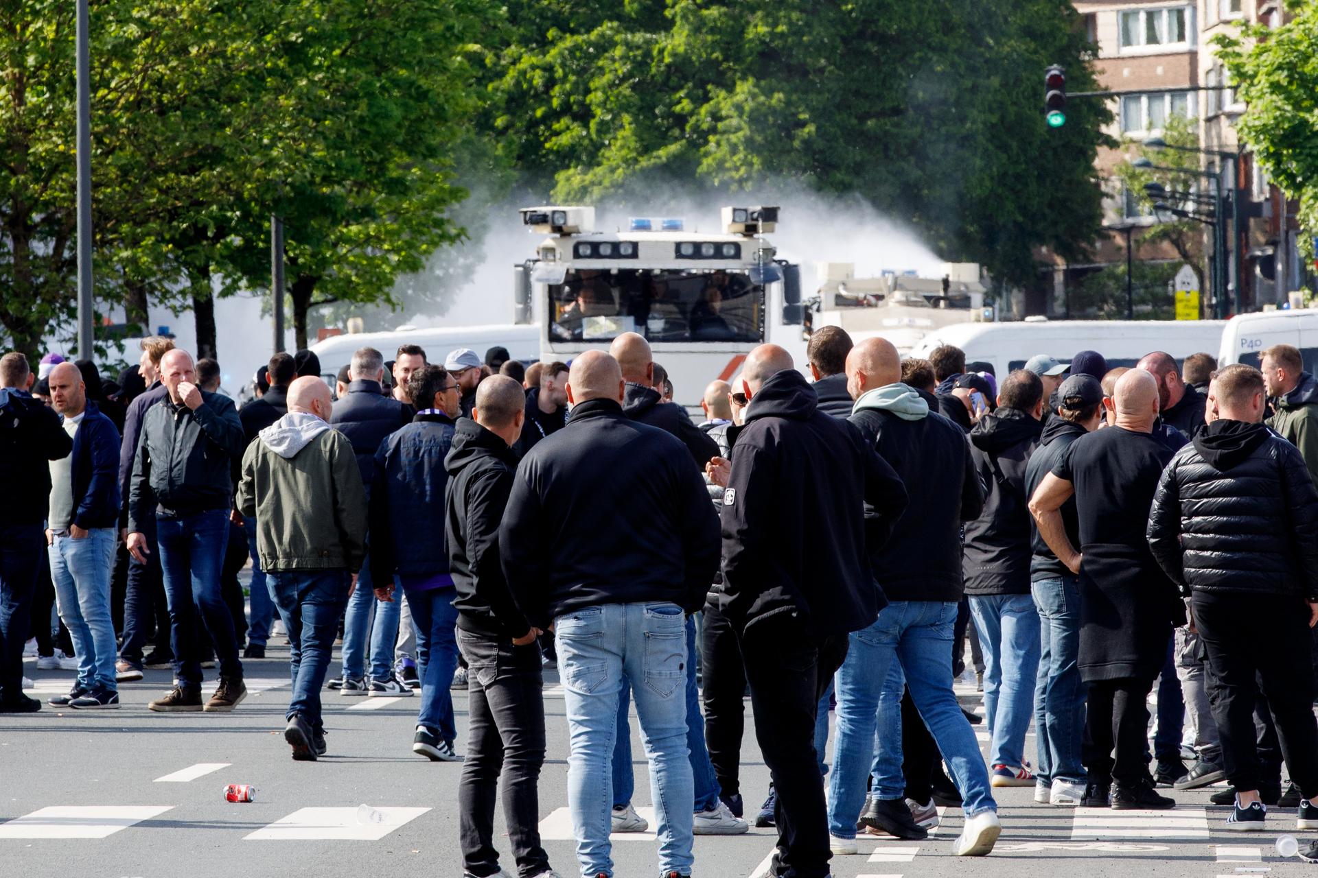 Riot police and soccer fans pictured at an Anderlecht supporters village (fandorp) at the Atomium, before the final of the 'Croky Cup' Belgian soccer cup, between Club Brugge and RSC Anderlecht, Sunday 04 May 2025. BELGA PHOTO HATIM KAGHAT