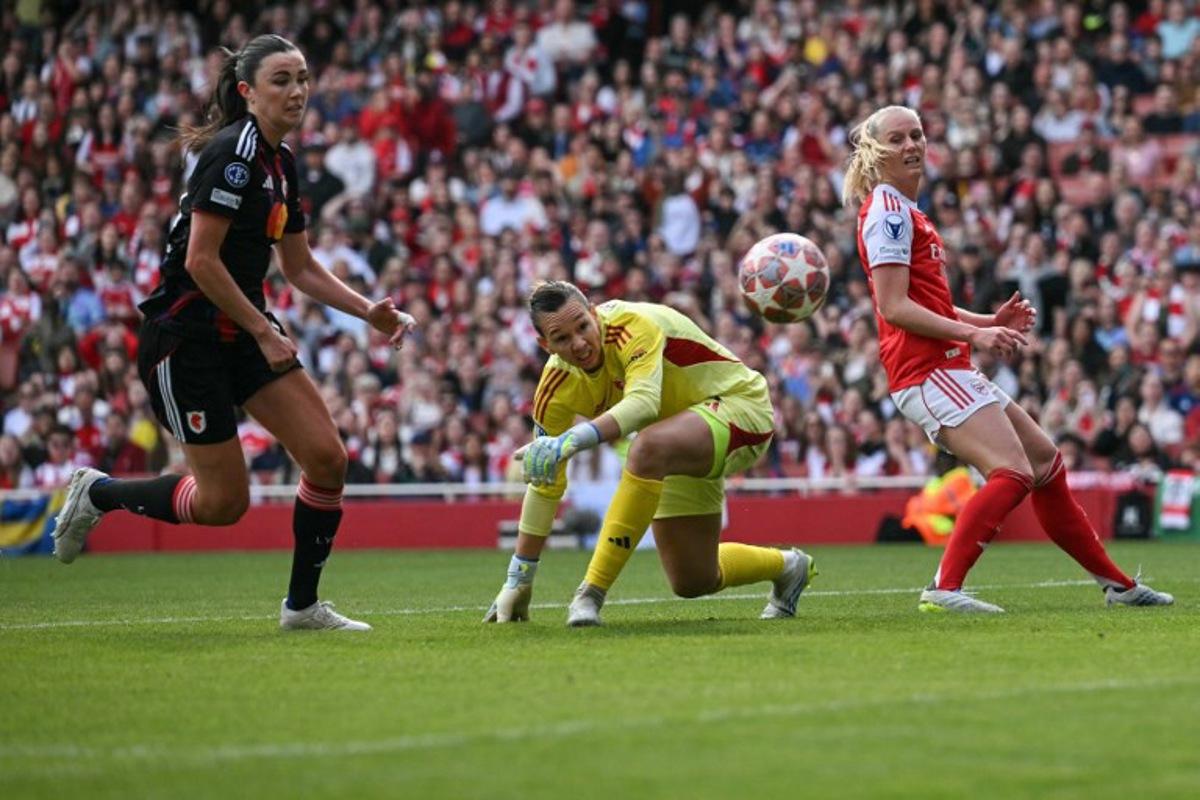 Arsenal's Swedish striker #25 Stina Blackstenius (R) and Lyon's Chilean goalkeeper #01 Christiane Endler (C) watch a bobbled ball to in for a goal during the women's UEFA Champions League first-leg semi-final football match between Arsenal and OL Lyonnes at the Emirates Stadium, north London, on April 26, 2026.  Glyn KIRK / AFP