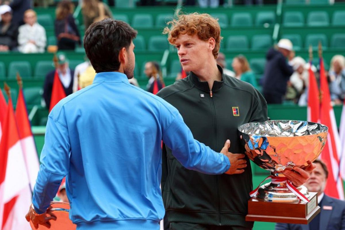Italy's Jannik Sinner (R) embraces with Spain's Carlos Alcaraz after winning the Monte Carlo ATP Masters Series Tournament final tennis match on Court Rainier III at the Monte-Carlo Country Club in Roquebrune-Cap-Martin, south-eastern France on April 12, 2026.  Valery HACHE / AFP