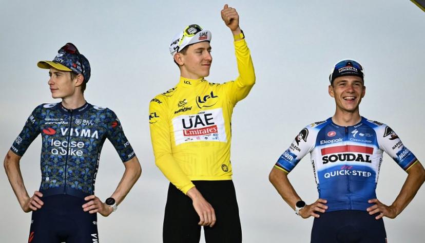 Overall winner UAE Team Emirates team's Slovenian rider Tadej Pogacar (C) celebrates on the podium , flanked by second-placed Team Visma - Lease a Bike team's Danish rider Jonas Vingegaard (L) and third-placed Soudal Quick-Step team's Belgian rider Remco Evenepoel (R) after the 21st and final stage of the 111th edition of the Tour de France cycling race, a 33,7 km individual time-trial between Monaco and Nice, on July 21, 2024.  Marco BERTORELLO / AFP