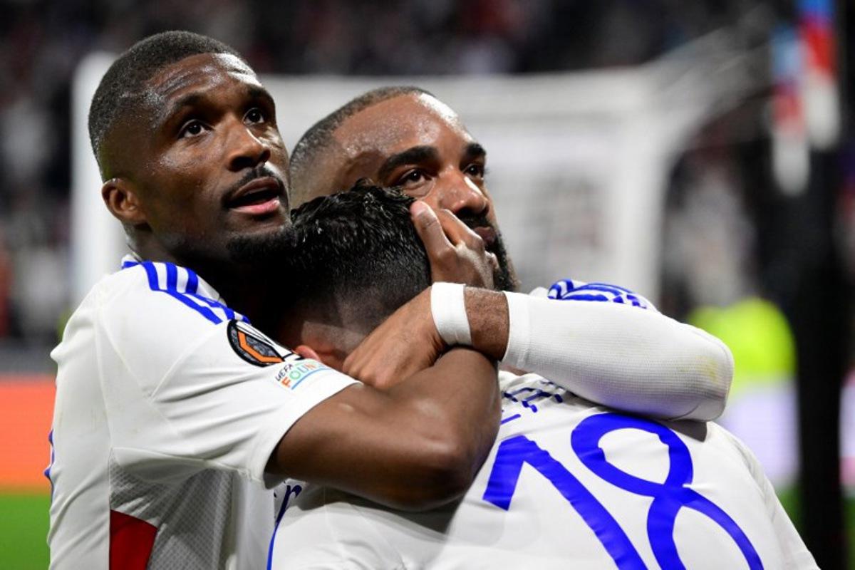 Lyon's French midfielder #18 Rayan Cherki celebrates, with Lyon's Angolan defender #22 Clinton Mata (L) and Lyon's French forward #10 Alexandre Lacazette, scoring his team's second goal during the UEFA Europa League Quarter final first leg football match between Olympique Lyonnais (OL) and Manchester United at the Parc Olympique Lyonnais Groupama stadium in Decines-Charpieu, central-eastern France, on April 10, 2025.  Olivier CHASSIGNOLE / AFP
