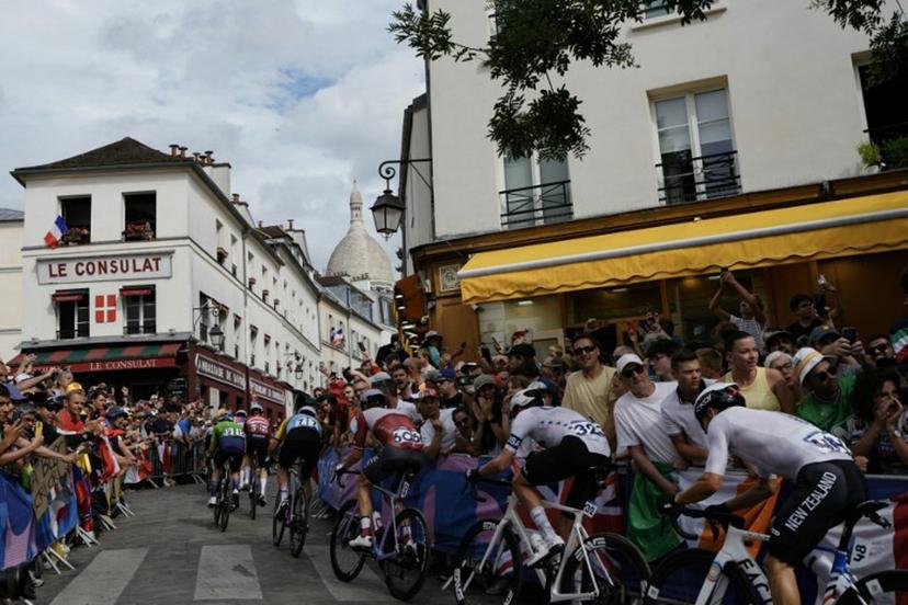 (FILES) The pack of riders cycles in Montmartre during the men's cycling road race during the Paris 2024 Olympic Games in Paris, on August 3, 2024. The Tour de France will pass by the Butte Montmartre on the final stage of the 2025 edition on July 27 to celebrate the fiftieth anniversary of the first final finish on the Champs-Elysées. Dimitar DILKOFF / AFP