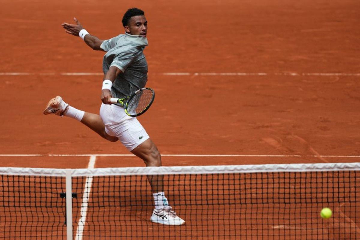 France's Arthur Fils plays a backhand return to Spain's Jaume Munar during their men's singles match on day 5 of the French Open tennis tournament on Court Suzanne-Lenglen at the Roland-Garros Complex in Paris on May 29, 2025.  Dimitar DILKOFF / AFP