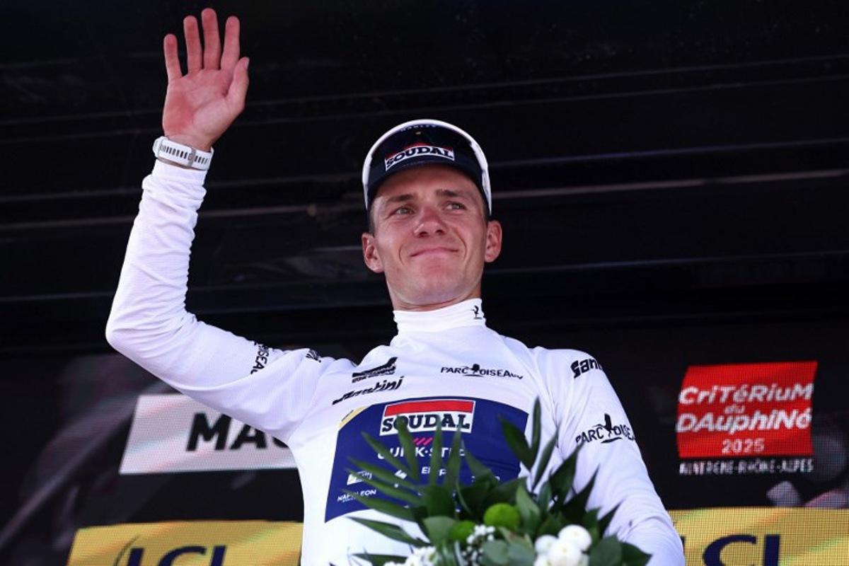 Soudal Quick-Step's Belgian rider Remco Evenepoel wearing the best young rider's white jersey celebrates on the podium of the 5th stage of the 77th edition of the Criterium du Dauphine cycling race, 183 km between Saint-Priest and Mâcon, on June 12, 2025. Anne-Christine POUJOULAT / AFP