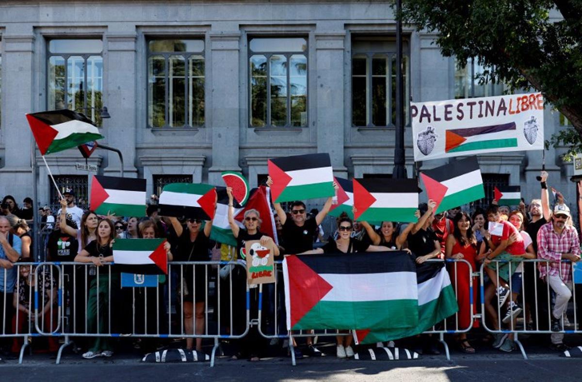 Pro-Palestinians protestors hold Palestinian flags during the 21st and last stage of the Vuelta a Espana 2025, a 101 km race between Alalpardo and Madrid, near Madrid's Cibeles fountain on September 14, 2025. The authorities have ramped up security for the Vuelta's final stage in Madrid, which was slightly shortened and will see 1,100 police officers deploy in the Spanish capital. Oscar DEL POZO / AFP