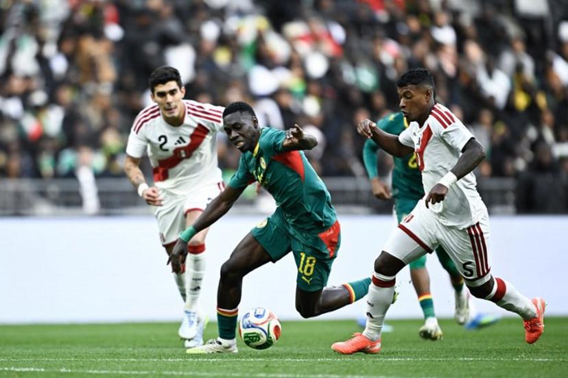 Senegal's forward #18 Ismaila Sarr (C) fight Peru's defender #05 Miguel Araujo (R) during the international friendly football match between Senegal and Peru at the Stade de France in Saint-Denis, north of Paris, on March 28, 2026. JULIEN DE ROSA / AFP
