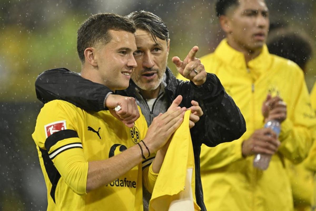 Dortmund's Croatian head coach Niko Kovac celebrates with Dortmund's Greek midfielder #19 Konstantinos Karetsas after the German first division Bundesliga football match between BVB Borussia Dortmund and Hamburg SV in Dortmund, western Germany on August 29, 2026. INA FASSBENDER / AFP