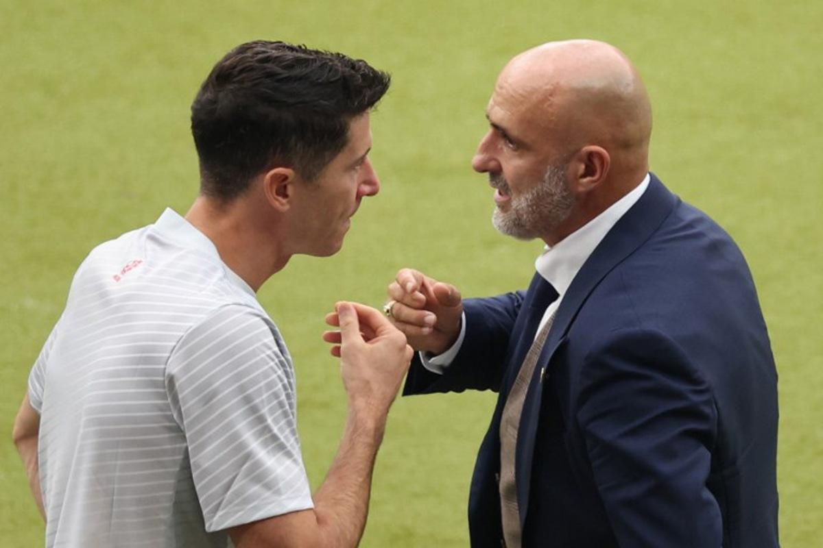 Poland's head coach Michal Probierz speaks with Poland's forward #09 Robert Lewandowski during the UEFA Euro 2024 Group D football match between Poland and Austria at the Olympiastadion in Berlin on June 21, 2024. Ronny HARTMANN / AFP