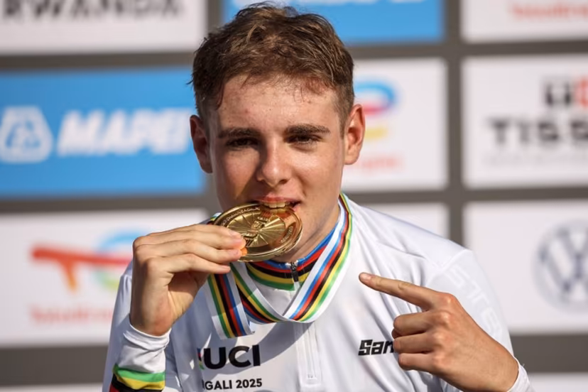Gold medallist Italian rider Lorenzo Mark Finn bites on his medal on the podium following the men's U23 road race cycling event during the UCI 2025 Road World Championships, in Kigali, on September 26, 2025. Anne-Christine POUJOULAT / AFP