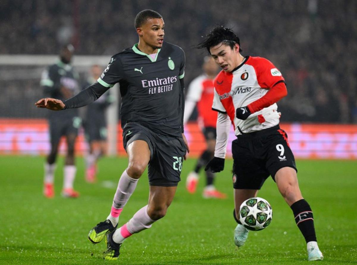 AC Milan's German defender #28 Malick Thiaw (L) fights for the ball with Feyenoord's Japanese forward #09 Ayase Ueda during the UEFA Champions League knockout phase play-off 1st leg football match between Feyenoord Rotterdam and AC Milan at the Stadion Feijenoord "De Kuip" in Rotterdam, on February 12, 2025. JOHN THYS / AFP