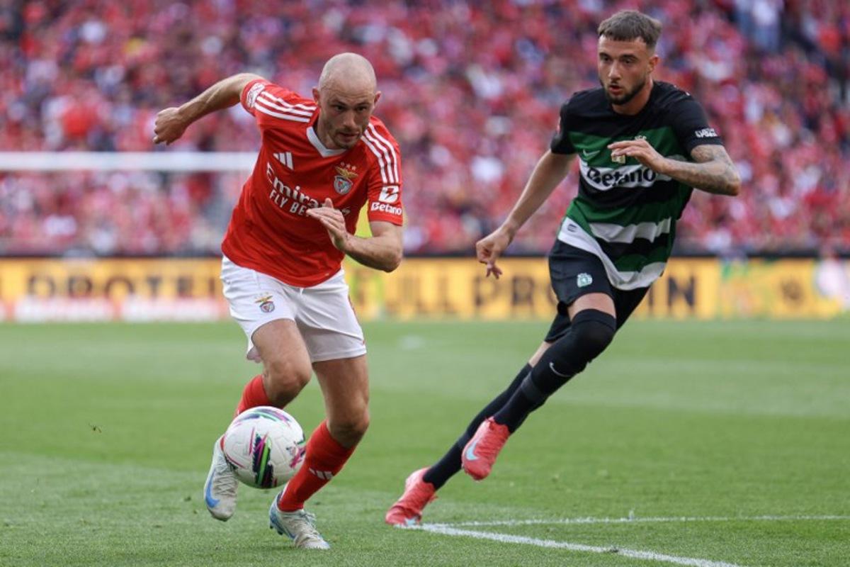 Benfica's Norwegian midfielder #08 Fredrik Aursnes (L) runs with the ball challenged by Sporting Lisbon's Belgian defender #06 Zeno Debast during the Portuguese League football match between SL Benfica and Sporting CP at Estadio da Luz in Lisbon, on May 10, 2025. FILIPE AMORIM / AFP