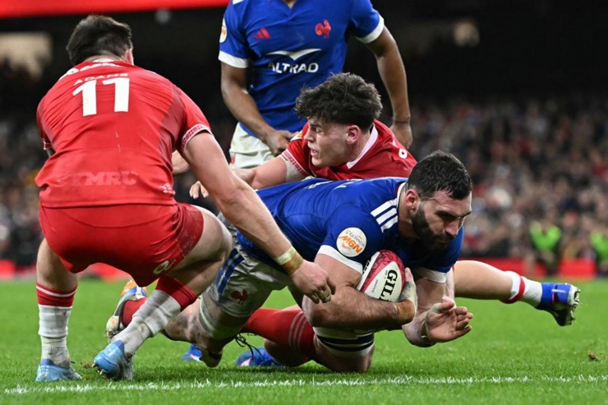 France's lock Charles Ollivon (R) dives for the line to score another try during the Six Nations international rugby union match between Wales and France at the Principality Stadium in Cardiff, south Wales, on February 15, 2026. Paul ELLIS / AFP