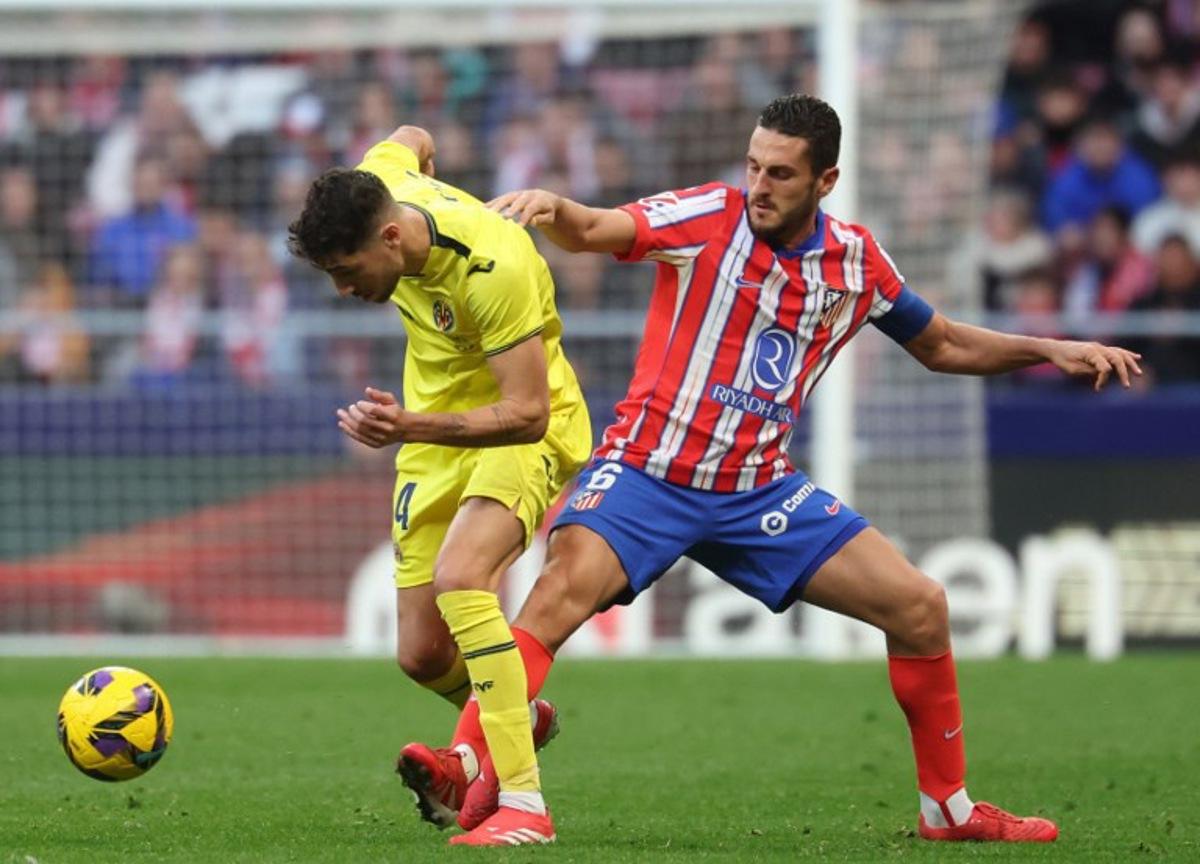 Villarreal's Spanish midfielder #14 Santi Comesana fights for the ball with Atletico Madrid's Spanish midfielder #06 Koke during the Spanish league football match between Club Atletico de Madrid and Villarreal CF at the Metropolitano stadium in Madrid on January 25, 2025. Pierre-Philippe MARCOU / AFP