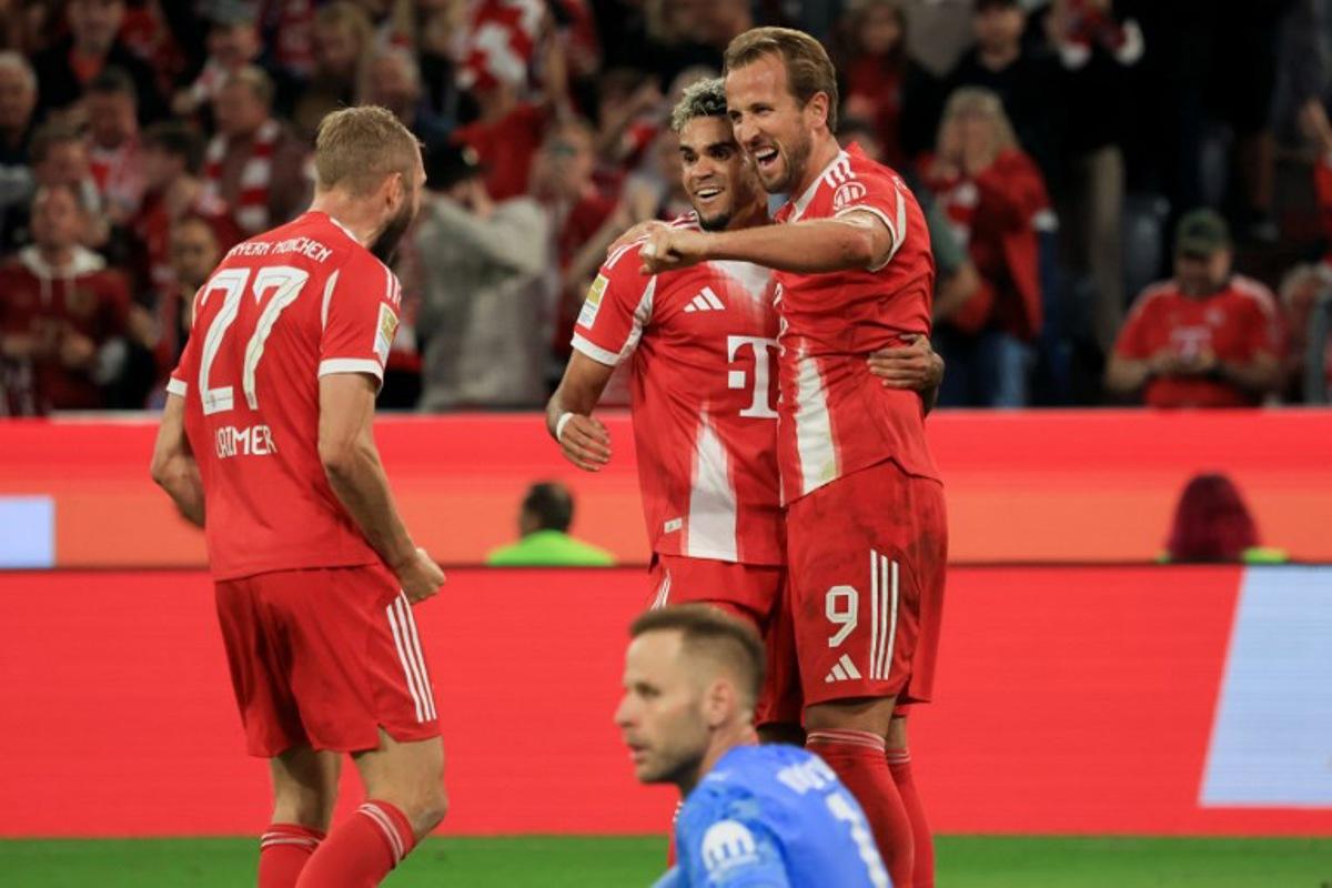 Bayern Munich's English forward #09 Harry Kane (R) celebrate with Bayern Munich's Colombian forward #14 Luis Diaz (2R) and Bayern Munich's Austrian midfielder #27 Konrad Laimer after scoring his team's fourth goal as Leipzig's Hungarian goalkeeper #01 Peter Gulacsi (front bottom) looks on during the German first division Bundesliga football match between FC Bayern Munich and RB Leipzig in Munich, southern Germany, on August 22, 2025. Karl-Josef Hildenbrand / AFP