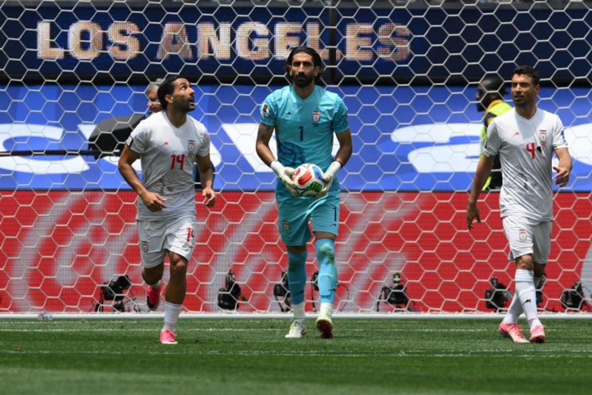 Iran's goalkeeper #01 Alireza Beiranvand holds the ball next to teammates midfielder #14 Saman Ghoddos and defender #04 Shojae Khalilzadeh during the 2026 World Cup Group G football match between Belgium and Iran at the Los Angeles Stadium in Inglewood on June 21, 2026. Patrick T. Fallon / AFP
