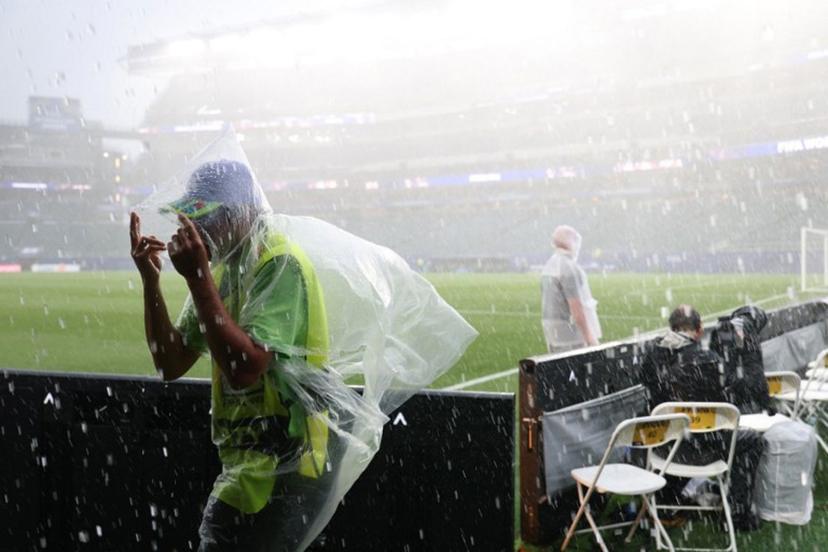 A photographer wears a raincoat as the 2026 World Cup Group I football match between France and Iraq is suspended due to adverse weather at the Philadelphia Stadium in Philadelphia on June 22, 2026. FRANCK FIFE / AFP