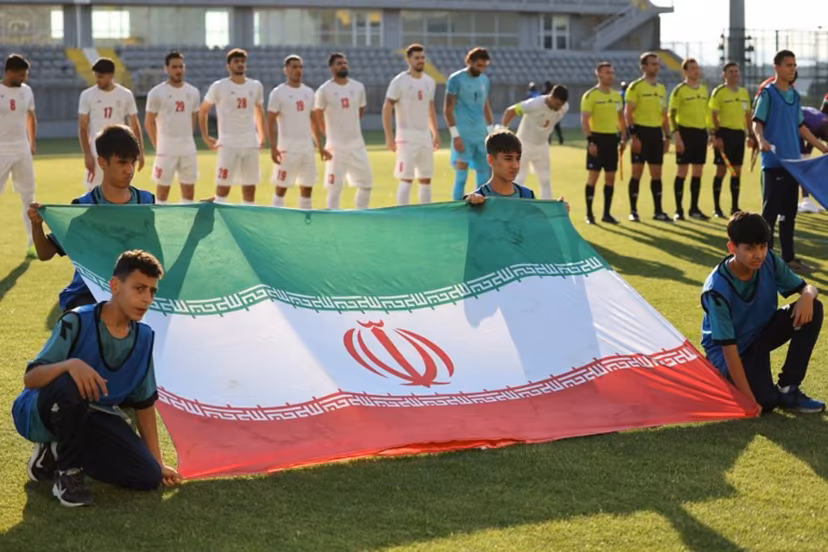 Iran's players stand behind the flag of Iran for photographers before the start of an international friendly football match between Iran and Gambia, in Antalya, southern Turkey, on May 29, 2026, as part of the team's preparation for the upcoming football World Cup. Oner SAN / AFP