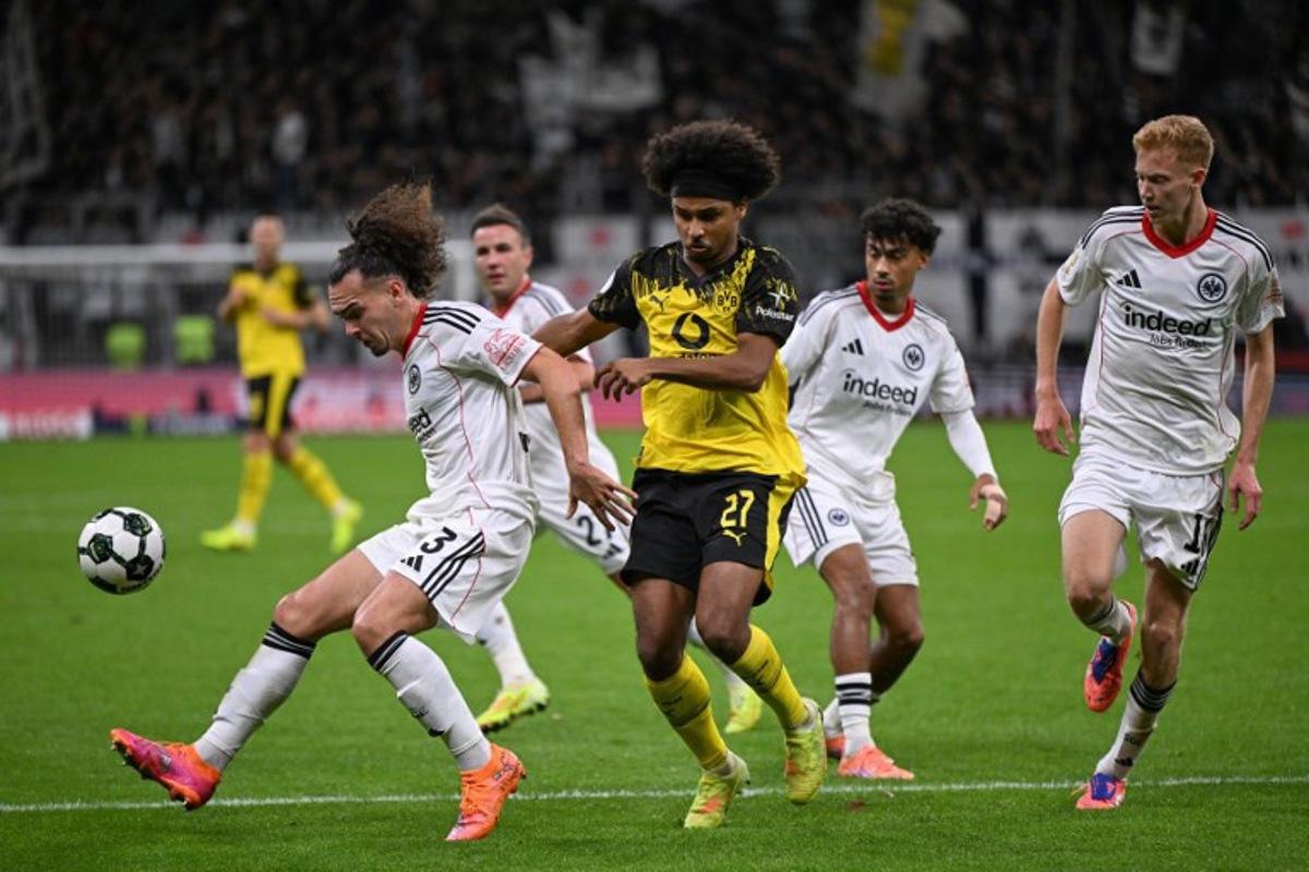 Frankfurt's Belgian defender #03 Arthur Theate (L) and Dortmund's German forward #27 Karim Adeyemi vie for the ball during the German Cup (DFB Pokal) second round football match between Eintracht Frankfurt and BVB Borussia Dormund in Frankfurt, western Germany on October 28, 2025. Kirill KUDRYAVTSEV / AFP