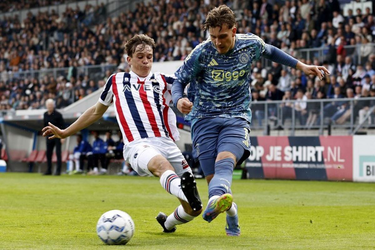 Willem II Dutch defender #48 Jens Mathijsen (L) fights for the ball with Ajax's Belgian forward #11 Mika Godts during the Dutch Eredivisie football match between Willem II and AFC Ajax at the Koning Willem II Stadium in Tilburg on April 13, 2025. MAURICE VAN STEEN / ANP / AFP