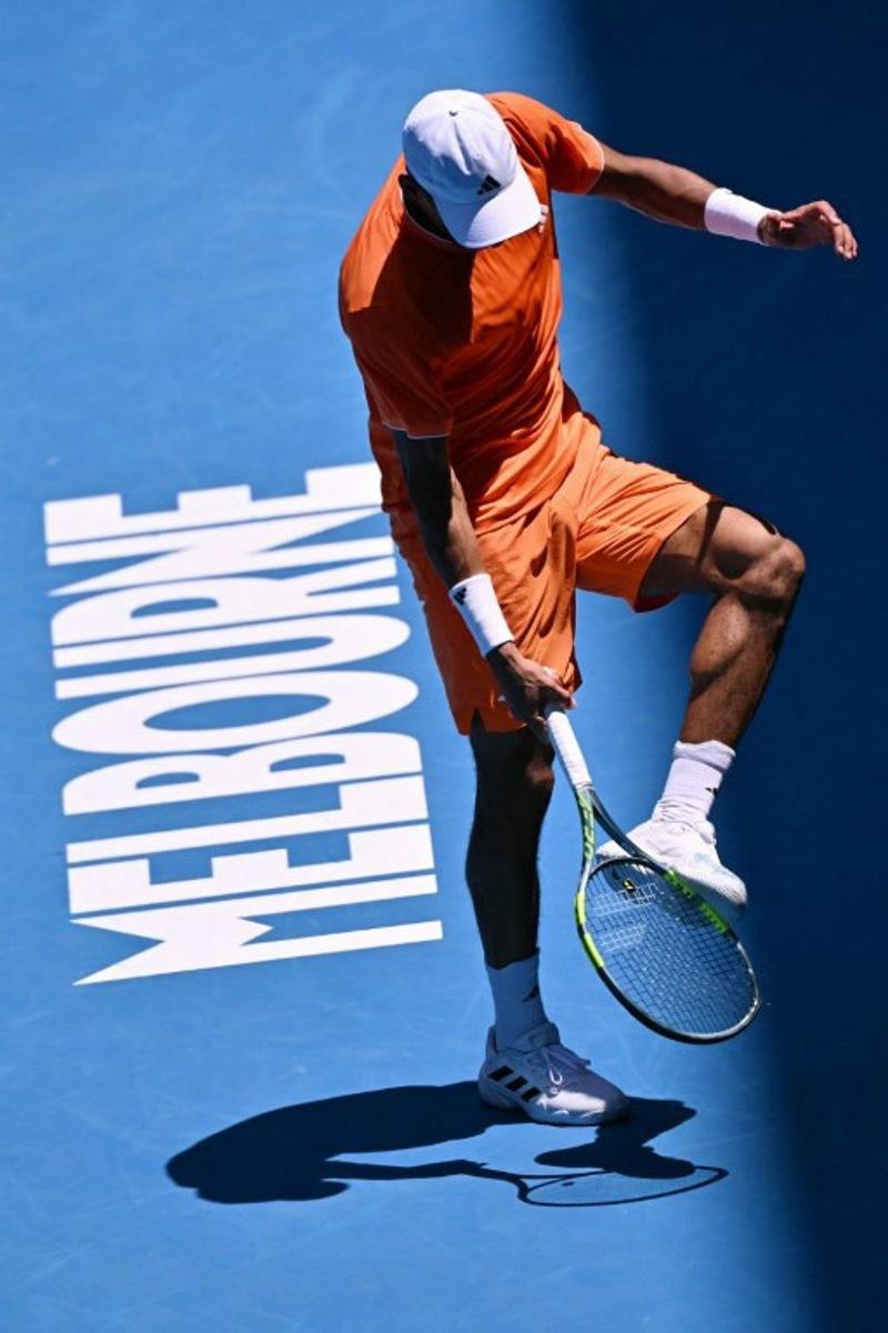 Canada's Felix Auger-Aliassime hits his foot with his racquet while playing against Portugal's Nuno Borges during their men's singles match on day two of the Australian Open tennis tournament in Melbourne on January 19, 2026. WILLIAM WEST / AFP