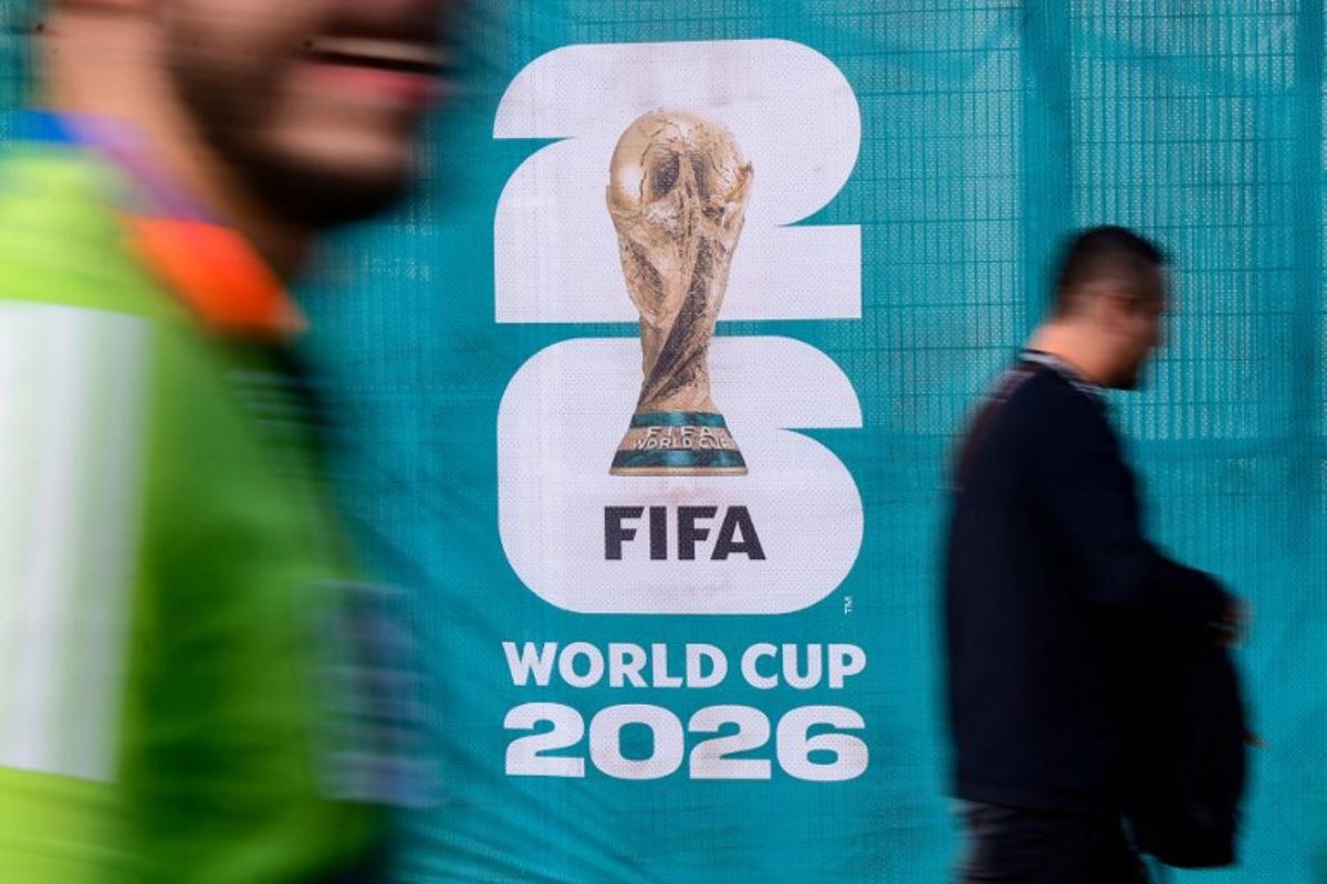 Pedestrians walk past an official competition logo on a fence ahead of the 2026 World Cup Group A football match between Mexico and South Africa at the Mexico City Stadium in Mexico City on June 11, 2026. Rodrigo Oropeza / AFP